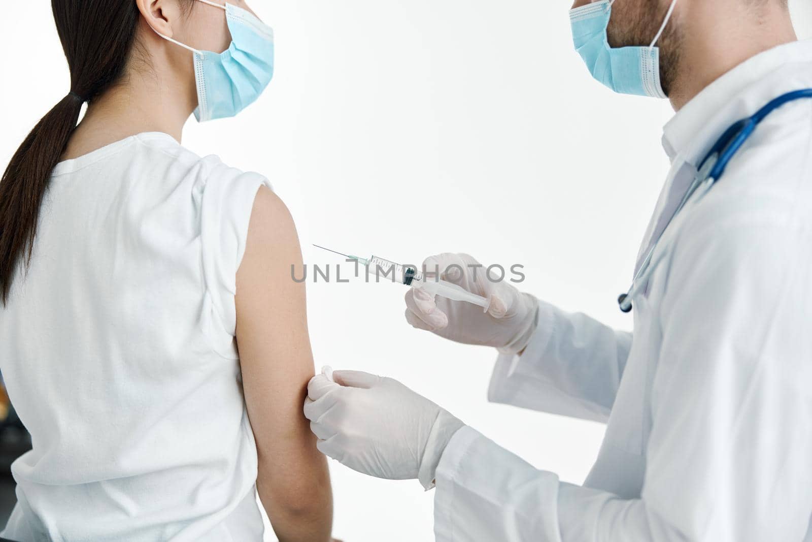 doctor in a white coat injecting a woman's shoulder vaccination gloves by SHOTPRIME
