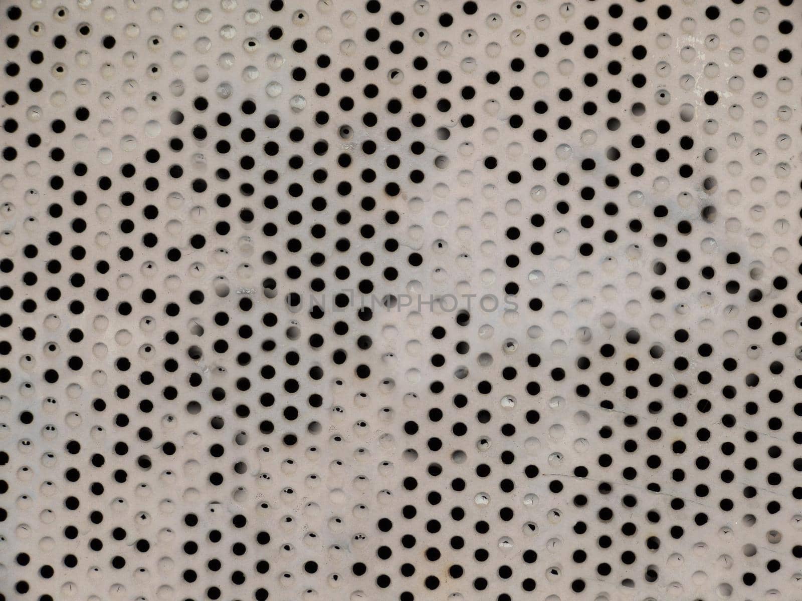 An old metal sheet with round holes on the surface.Texture or background