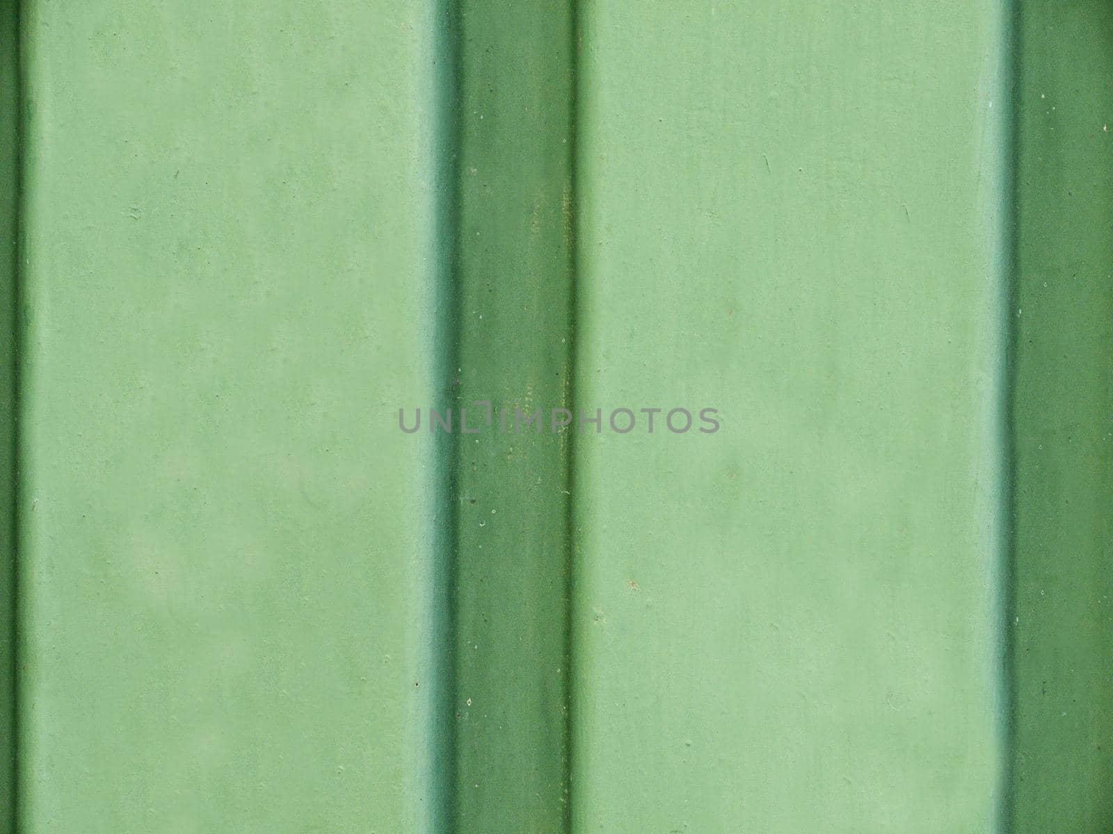 Green smooth concrete wall with striped vertical stripes close-up.Texture or background