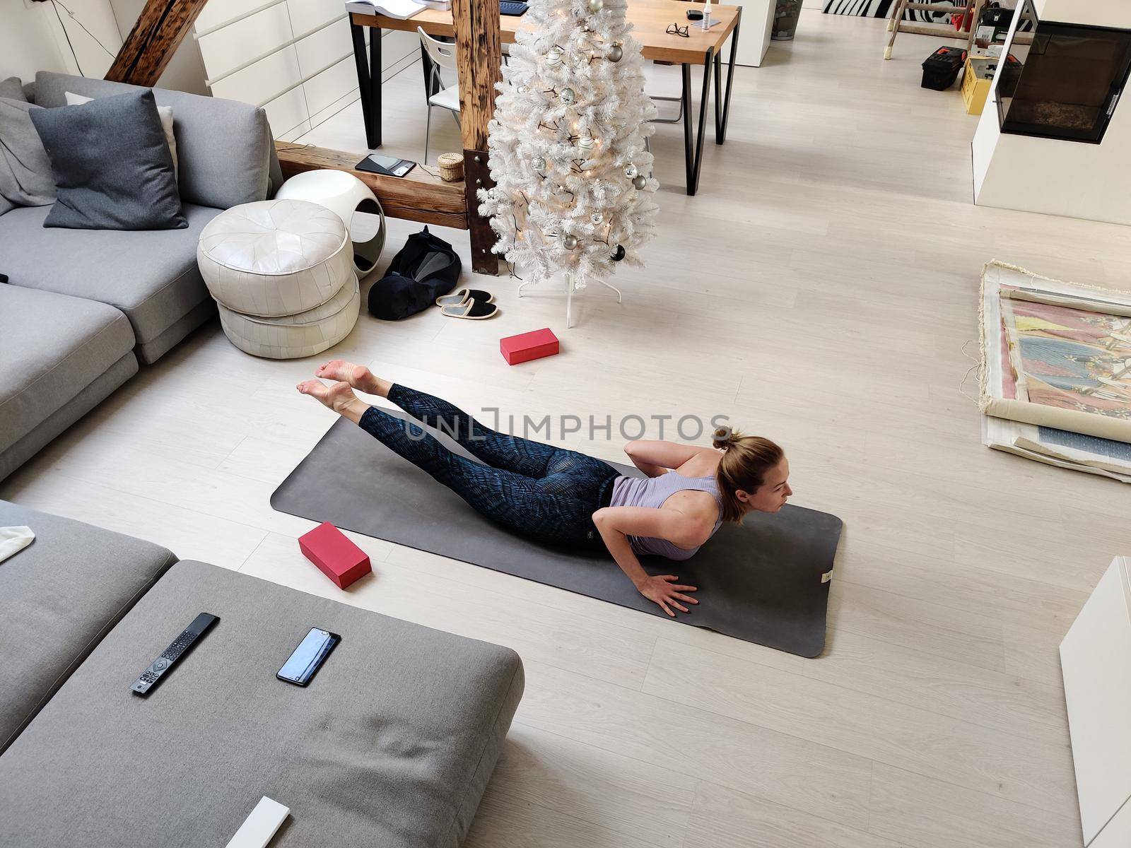 Beautiful blonde woman doing home workout indoors. Woman practice yoga at home. Fit girl using workout tutorials for healthy active lifestyle. Woman using quarantine for home workouts. by kasto