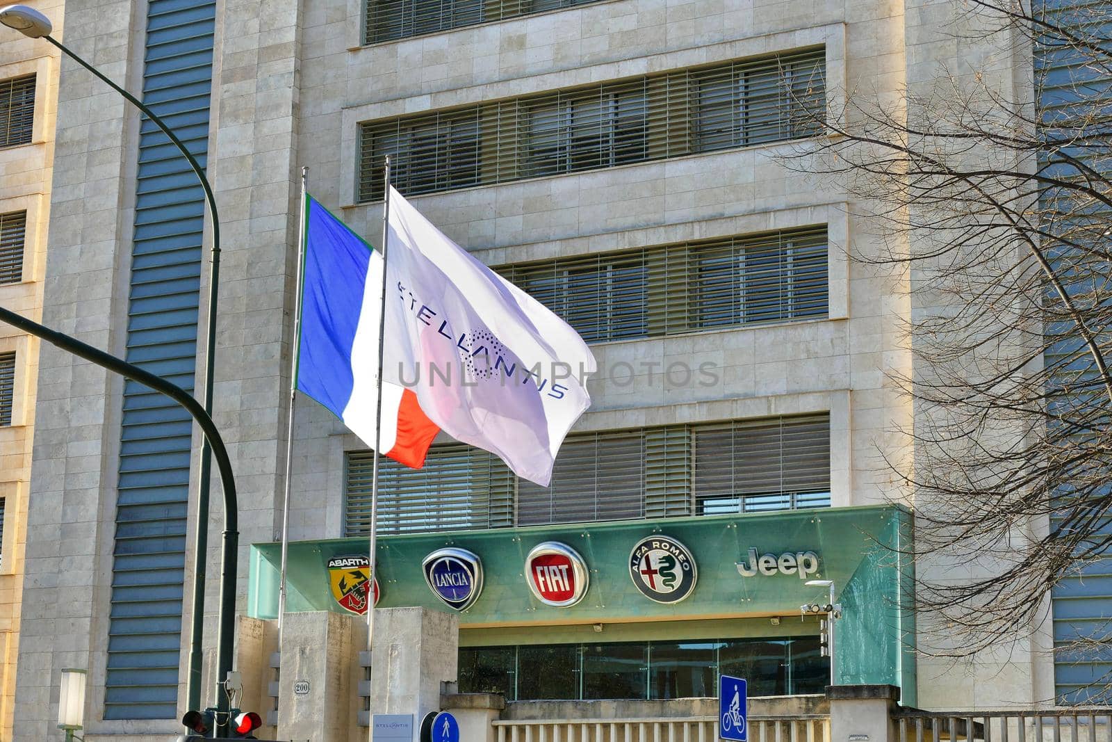 Fake French flag and Stellantis corporation flag at italian headquarters after merging between Groupe PSA and FCA automotive representing the actual control Turin Italy January 25 2021 by lemar