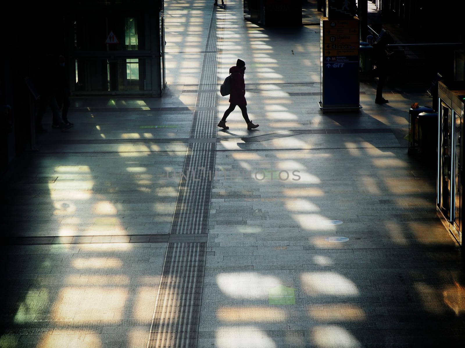Woman silhouette walking wearing protective mask in train station Turin Italy January 13 2021 deliberated motion blurWoman silhouette walking wearing protective mask in train station Turin Italy January 13 2021 deliberated motion blur