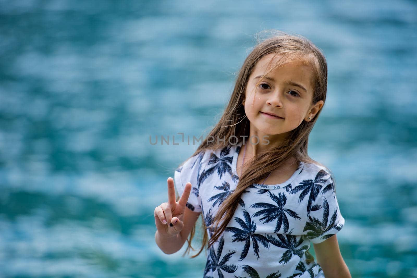 Portrait of a cute girl on a turquoise water background.