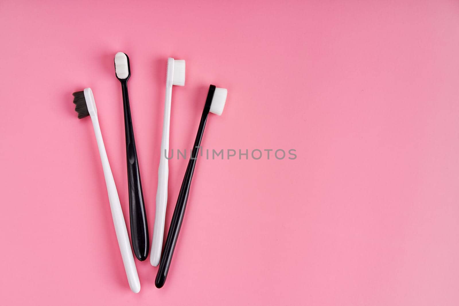 Fashionable toothbrush with soft bristles. Popular toothbrushes. Hygiene trends. Kit of toothbrushes on pink background by Try_my_best