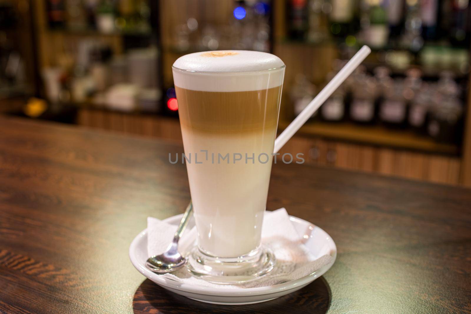 coffee latte in glass cup on wooden table in bar.