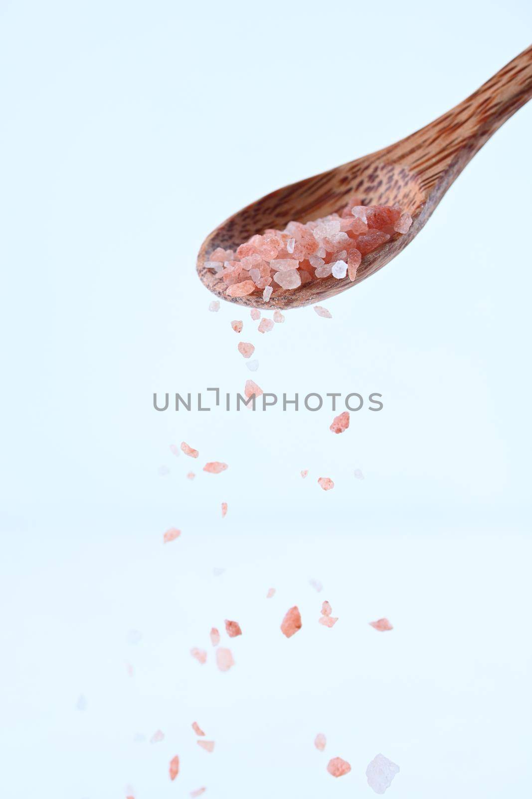 Pink Himalayan salt on a wooden spoon isolated on white background. by sashokddt