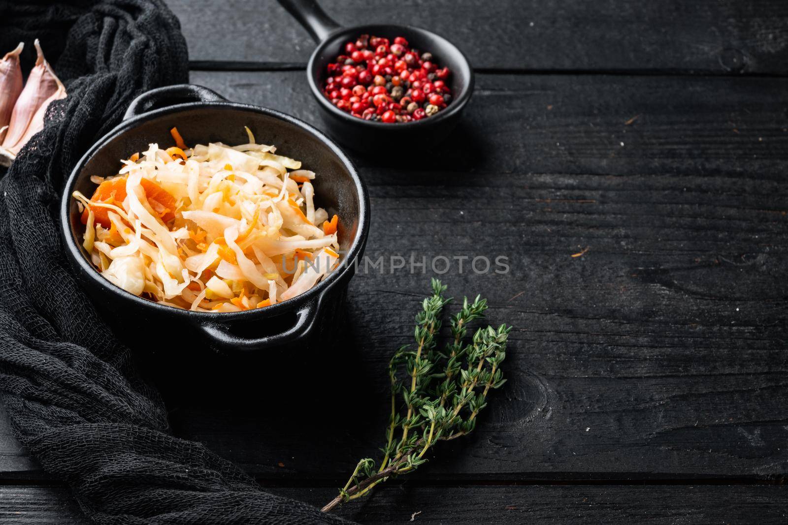 Homemade sauerkraut with cumin set, on black wooden table background , with space for text copyspace