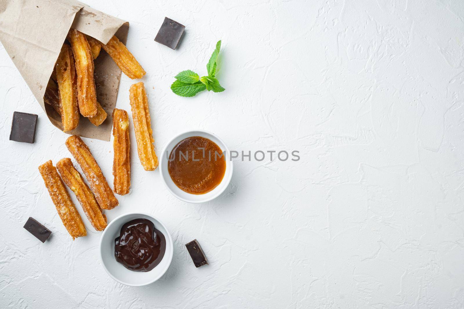 Churros with caramel, Traditional Spanish cusine, on white background, top view flat lay with space for text, copyspace