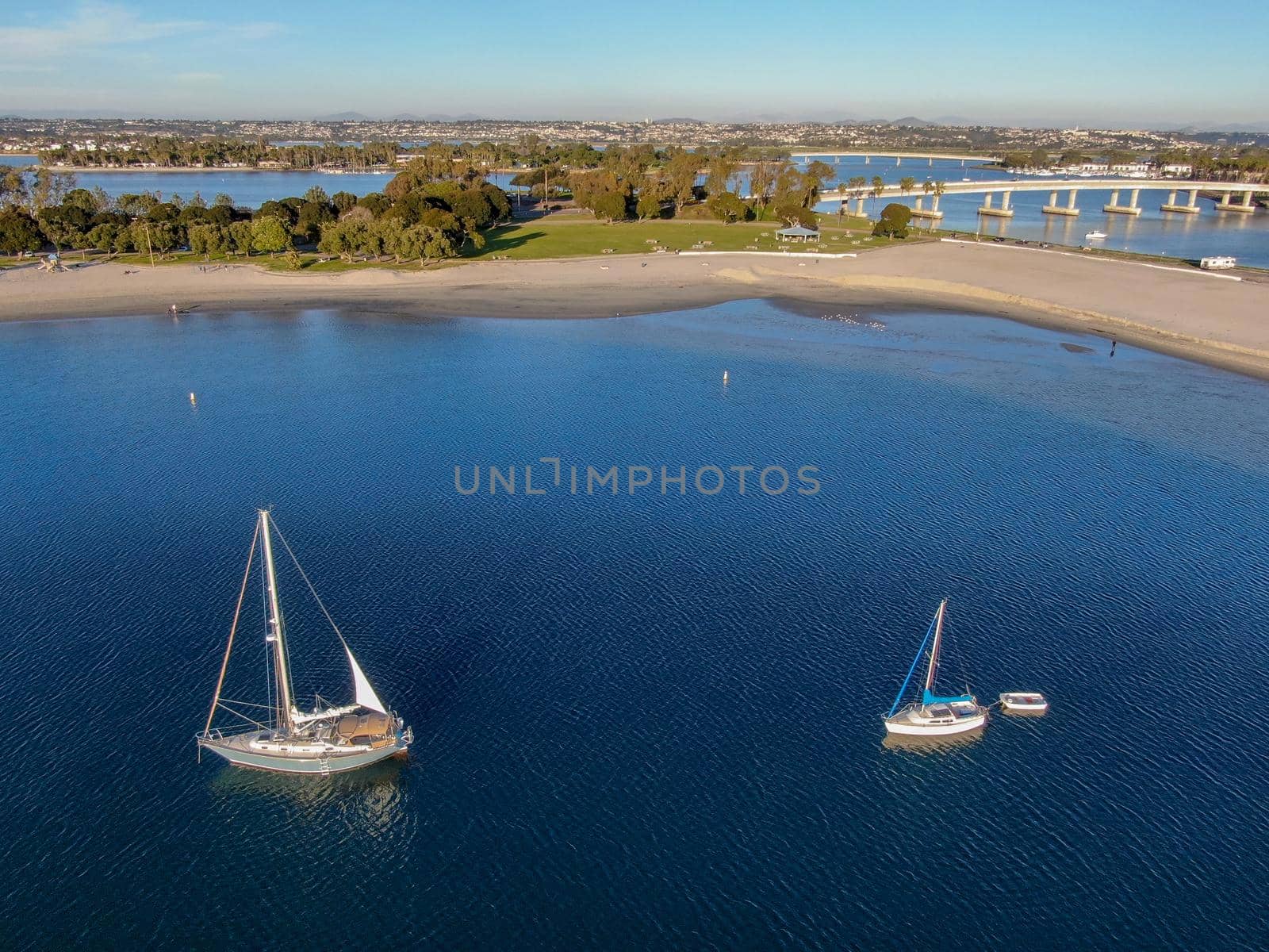 Aerial view of small sail boats in the Mission Bay of San Diego, California, USA. Small sailing ship yachts anchored in the bay. March 22nd, 2020