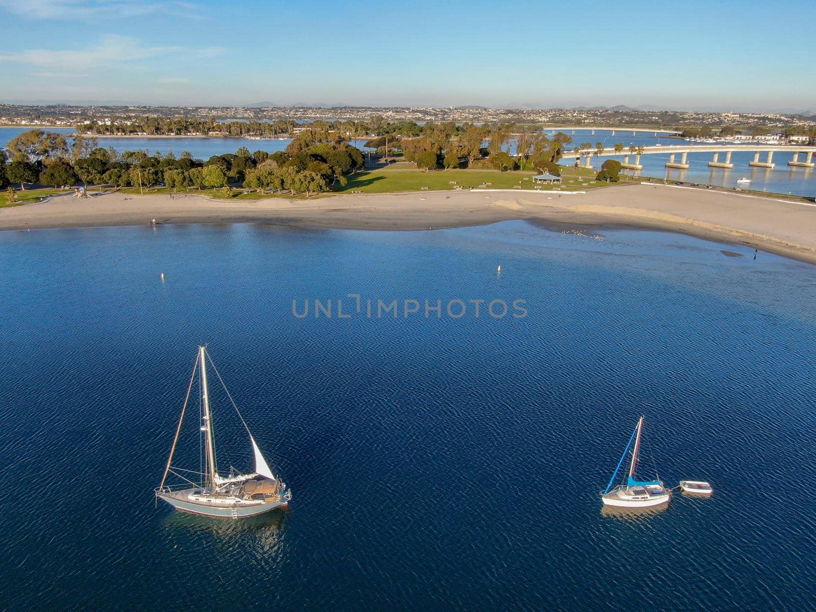 Aerial view of small sail boats in the Mission Bay of San Diego, California, USA. Small sailing ship yachts anchored in the bay. March 22nd, 2020