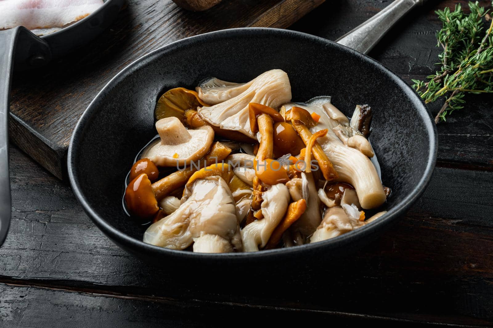 Wild mushrooms Boletus edulis and cap boletus in a jar set, on old dark wooden table background