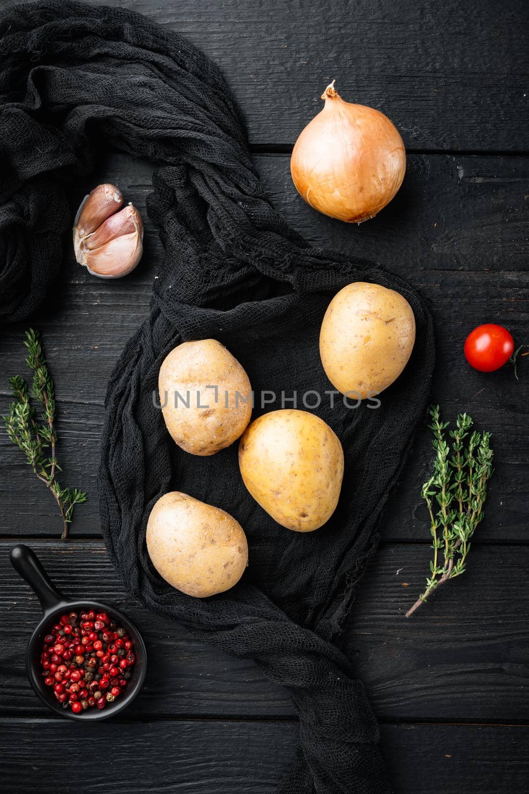 Fresh Pile of potatoes set, on black wooden table background, top view flat lay