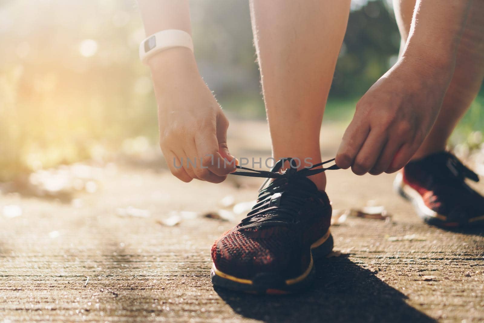 Woman wear running shoe on to walking and running on nature green background.Health exercise concept.