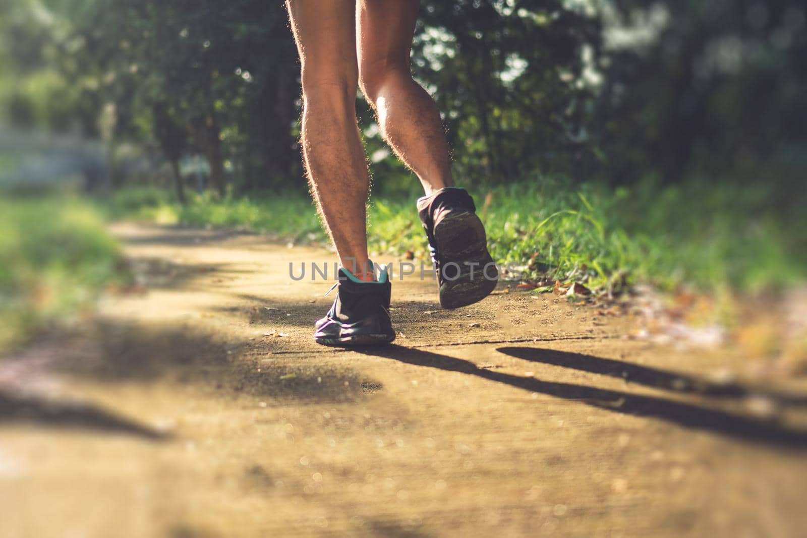Woman wear running shoe on to walking and running on nature green background.Health exercise. by Suwant