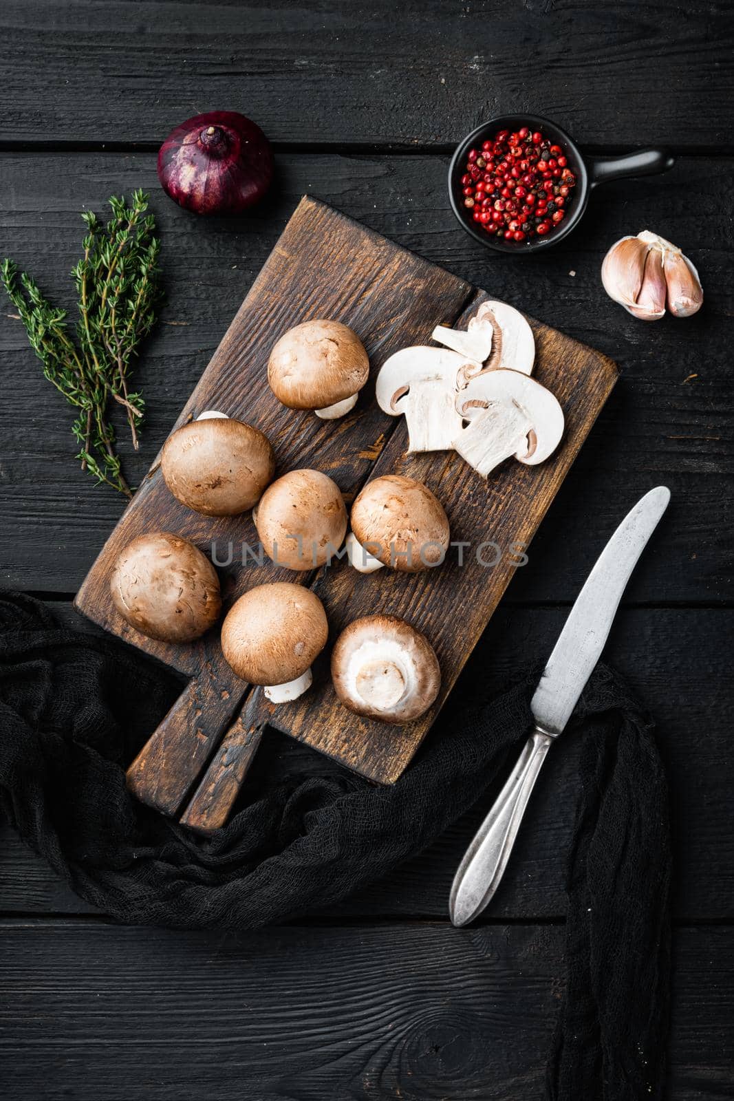 Brown champignons mushroom set, on black wooden table background, top view flat lay