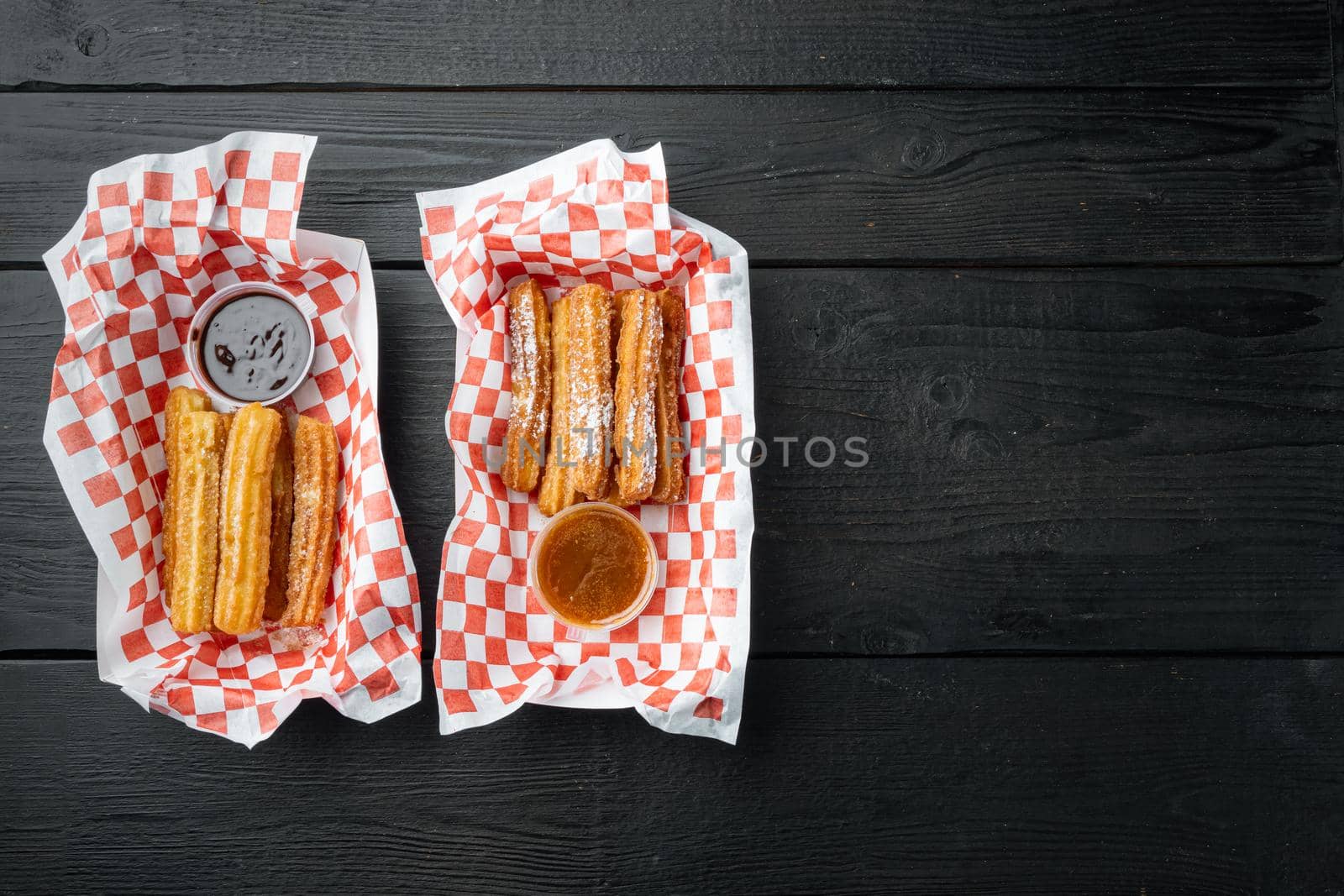 Fried Crullers in Brown, Take Away Bag in paper tray, on black wooden table background, top view flat lay with space for text, copyspace