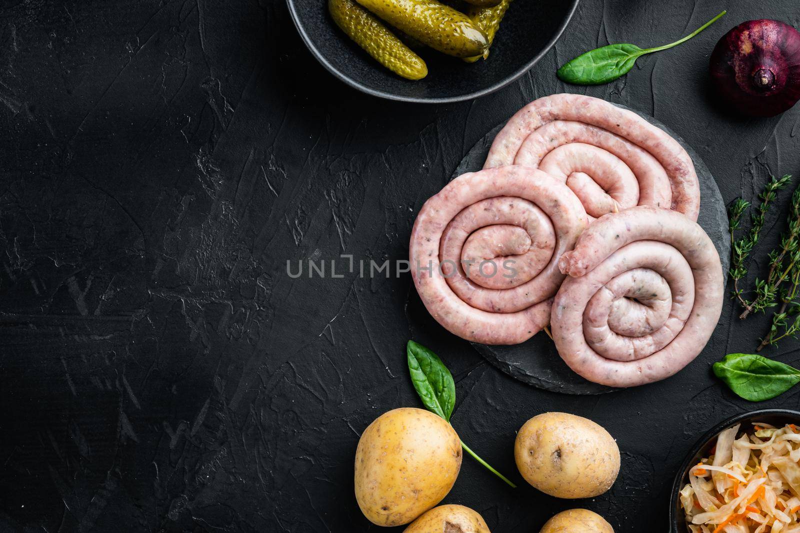 Raw meat sausage set, on black background, top view flat lay , with space for text copyspace