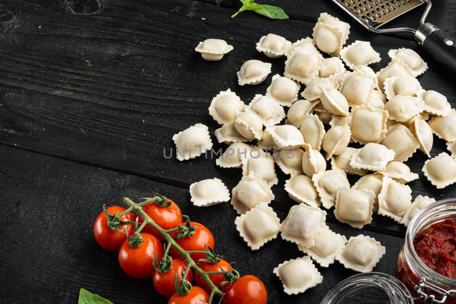 Ravioli with Parmesan and Basil set, on black wooden table background , with copyspace and space for text