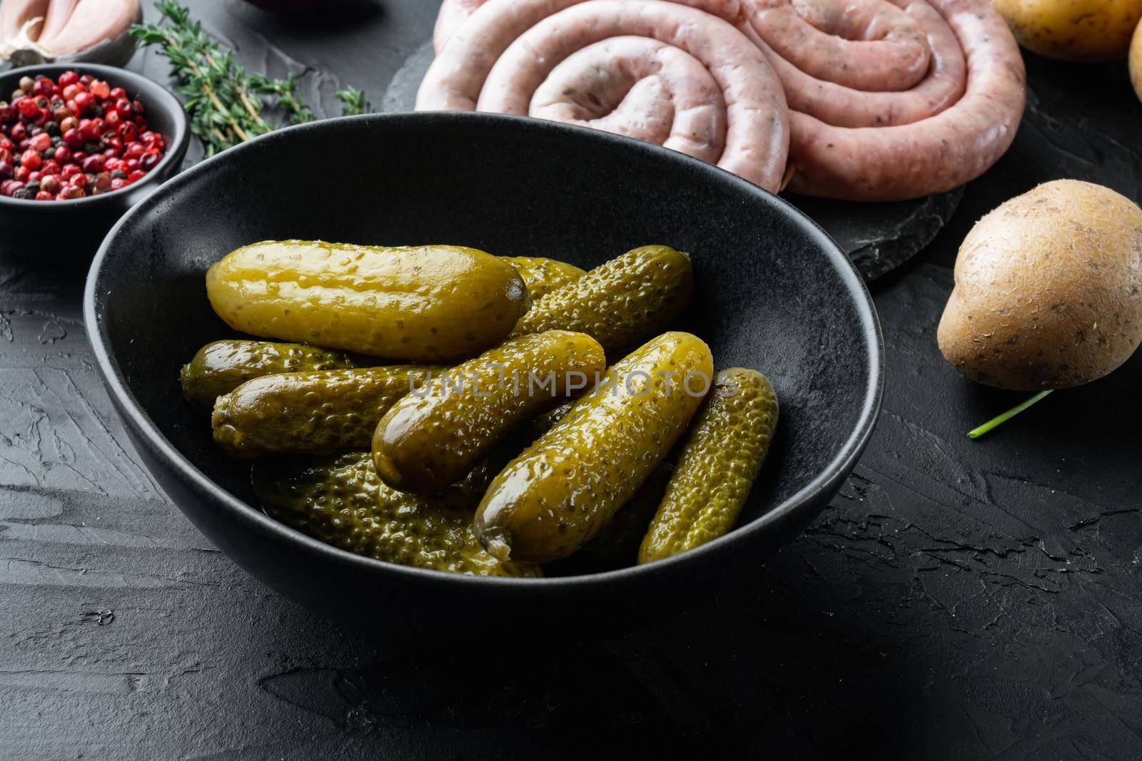 Pickled cucumbers, on black background