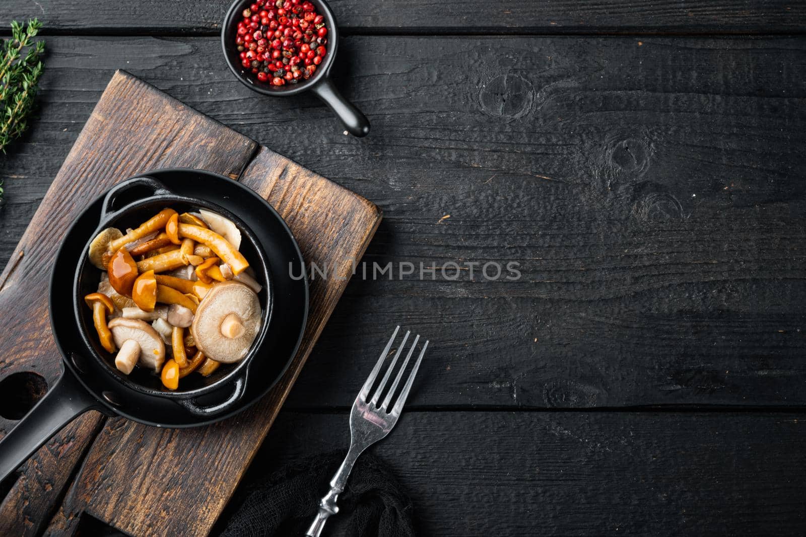 Marinated mushrooms set, on black wooden table background, top view flat lay , with space for text copyspace