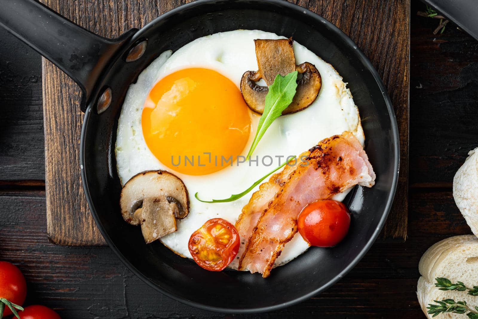 Fried Egg with ingredient in cast iron frying pan, on old dark wooden table background, top view flat lay
