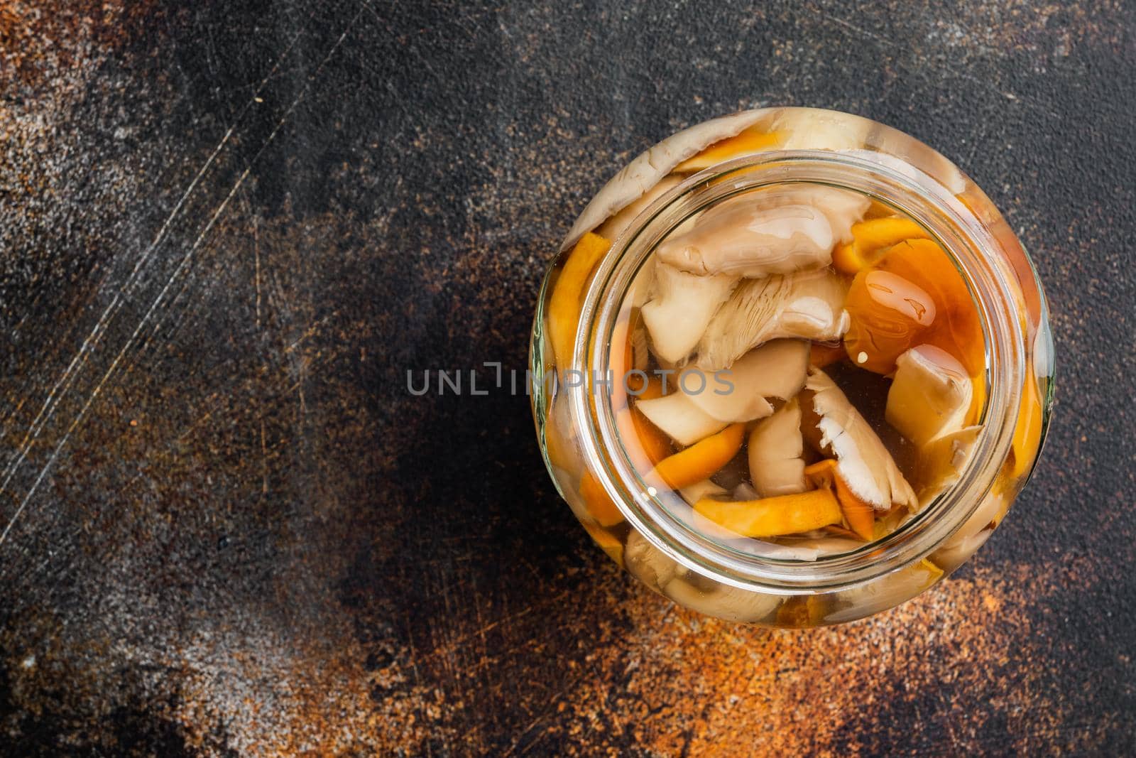 Canned mushrooms in oil set, on old dark rustic background, top view flat lay , with space for text copyspace