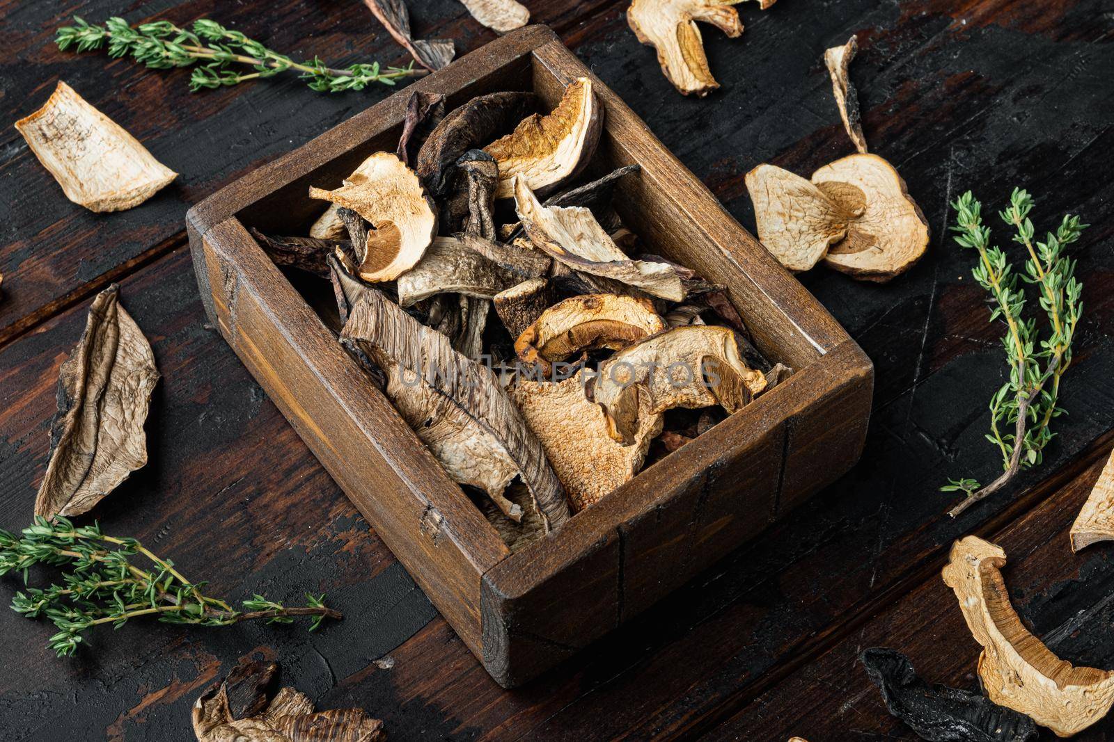 Dried wild mushrooms set, on old dark wooden table background
