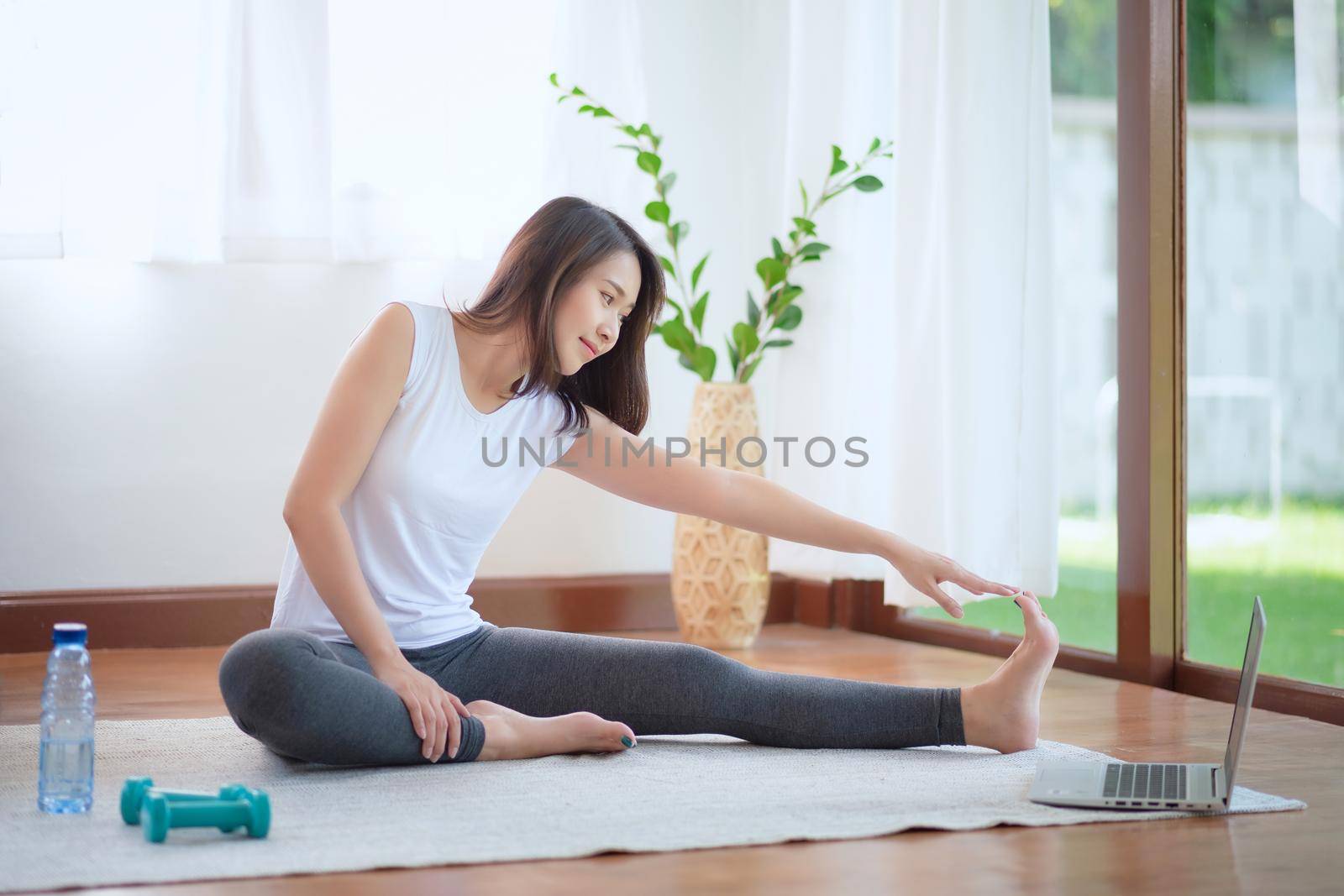 Beautiful asian woman staying fit by exercising at home for healthy trend lifestyle by Nuamfolio
