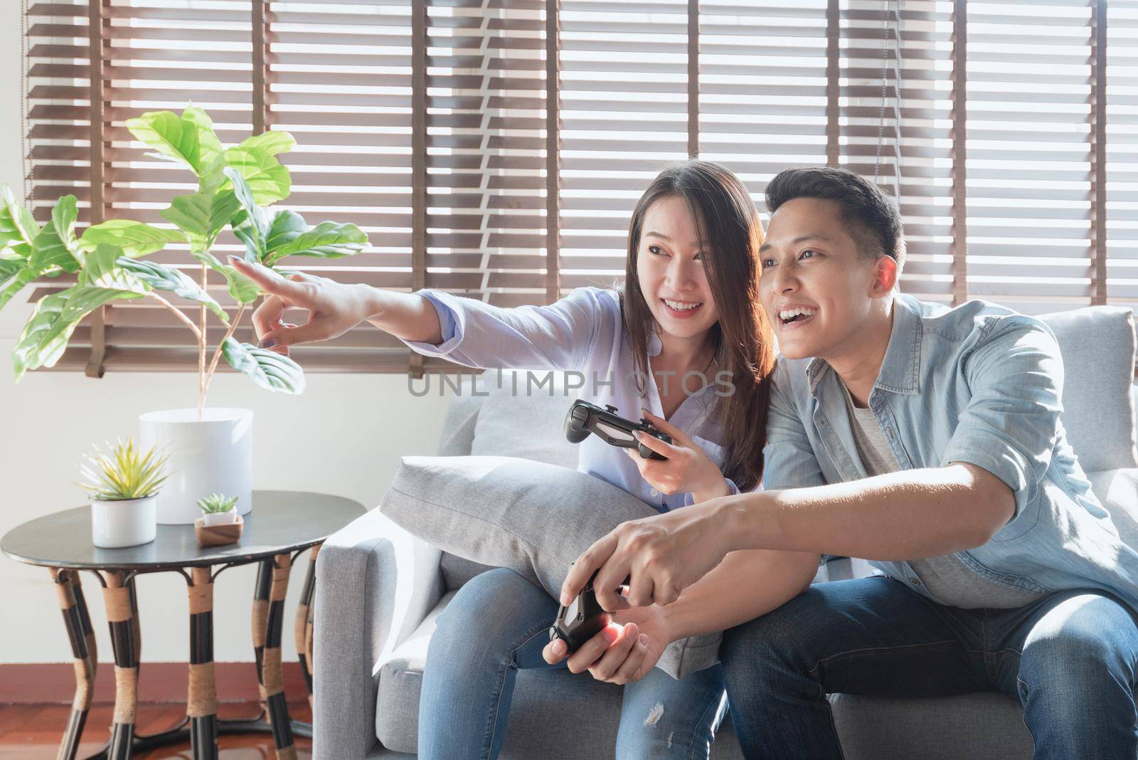 Asian couple lovers enjoy and play console game on vacation make more quality time of happiness together at home