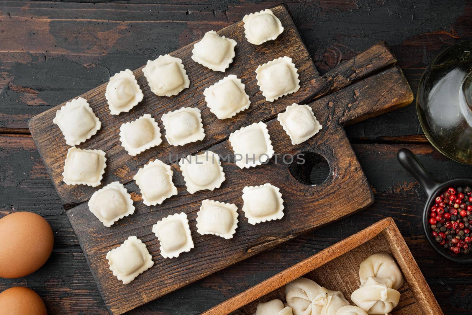 Italian Ravioli ingredients with fresh ricotta leaves and tomatoes set on old dark wooden table background, top view flat lay