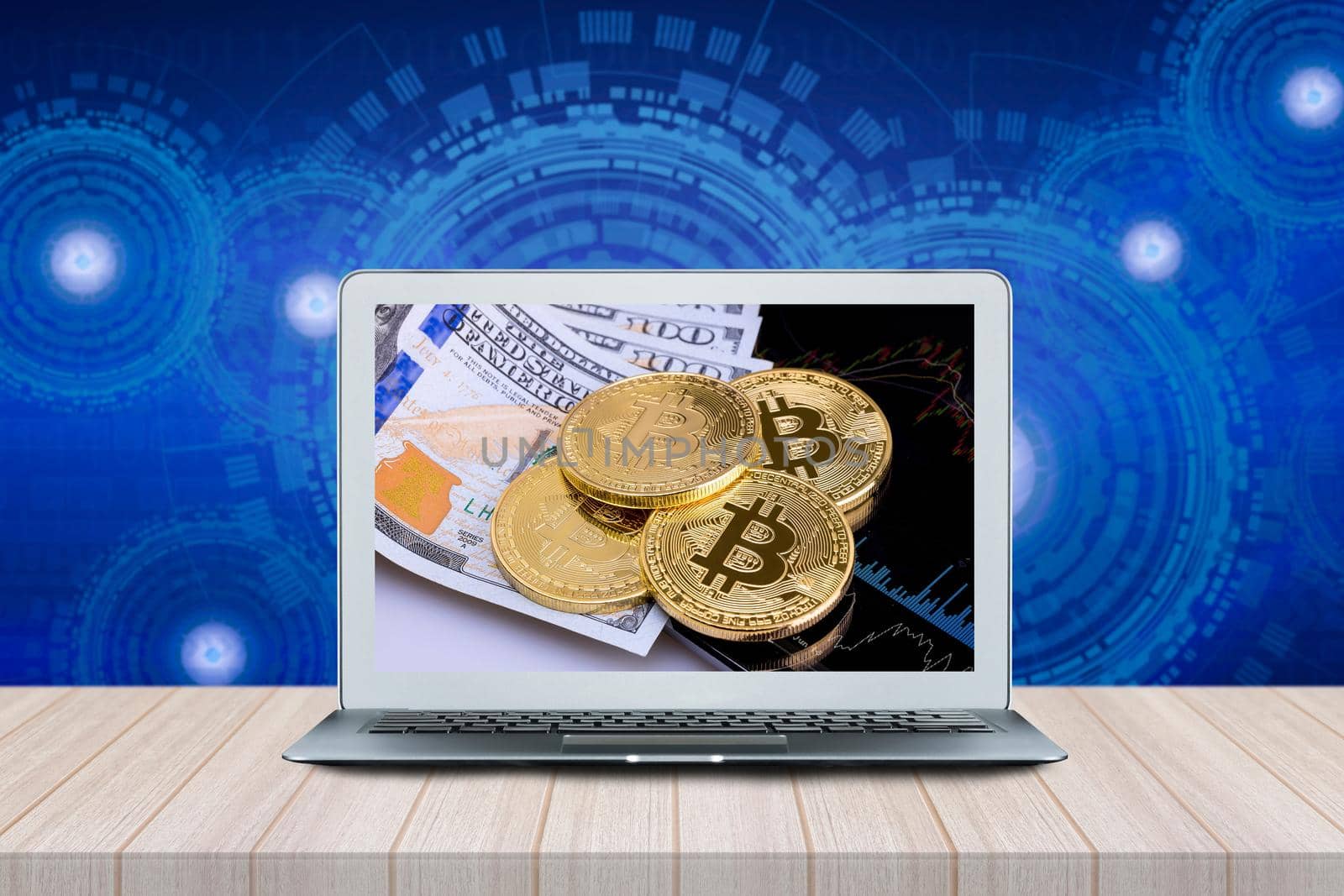 Smart Computer with Bitcoins on investment money moving graph on screen on wood table with futuristic technology background.