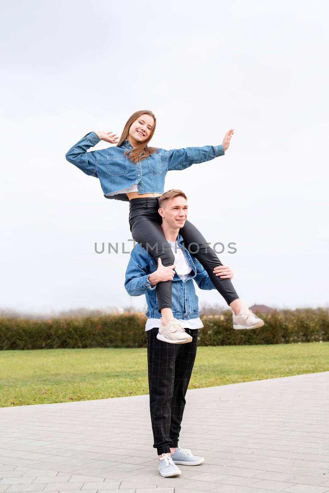 Young loving couple wearing jeans spending time together in the park having fun