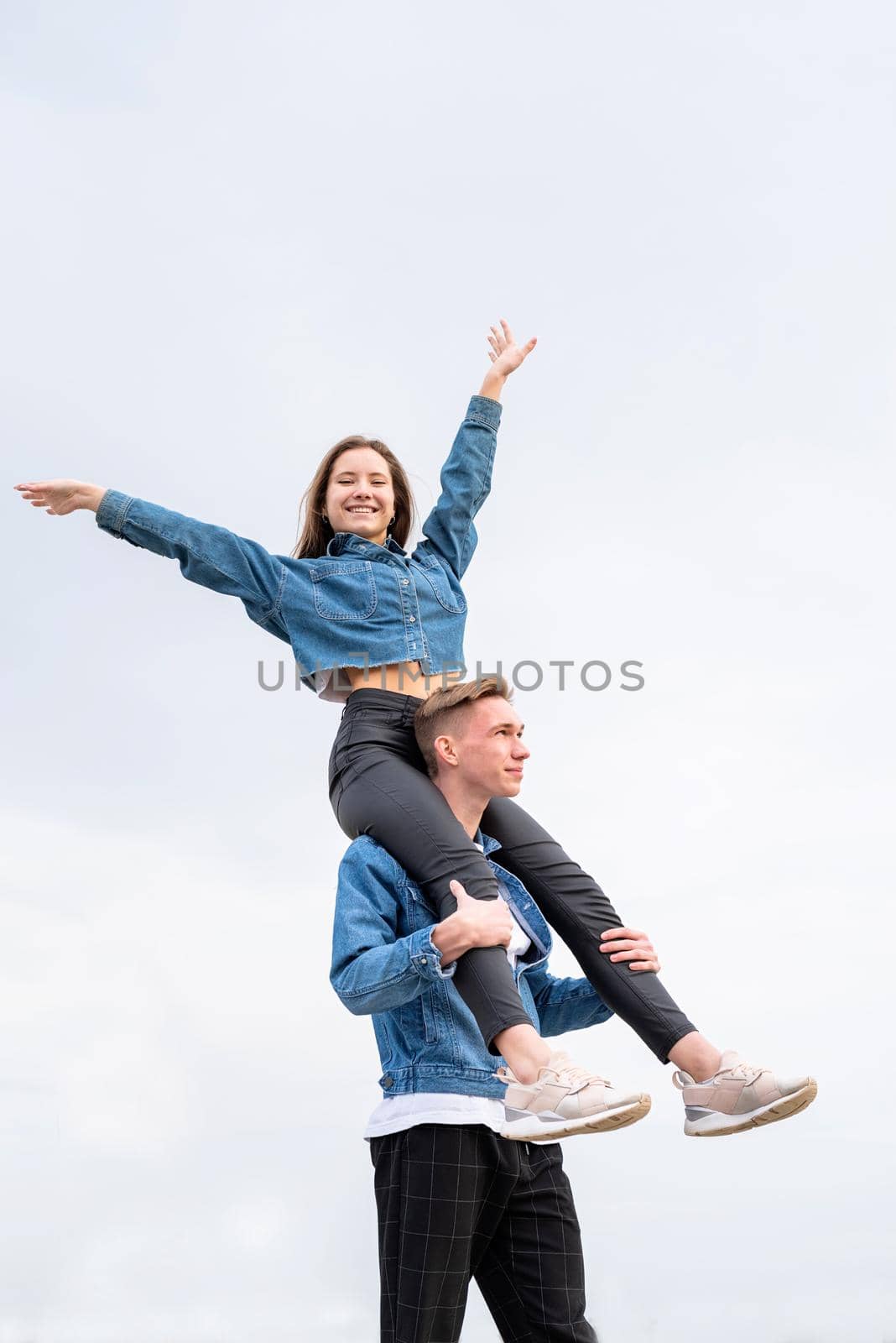 Young loving couple wearing jeans spending time together in the park having fun