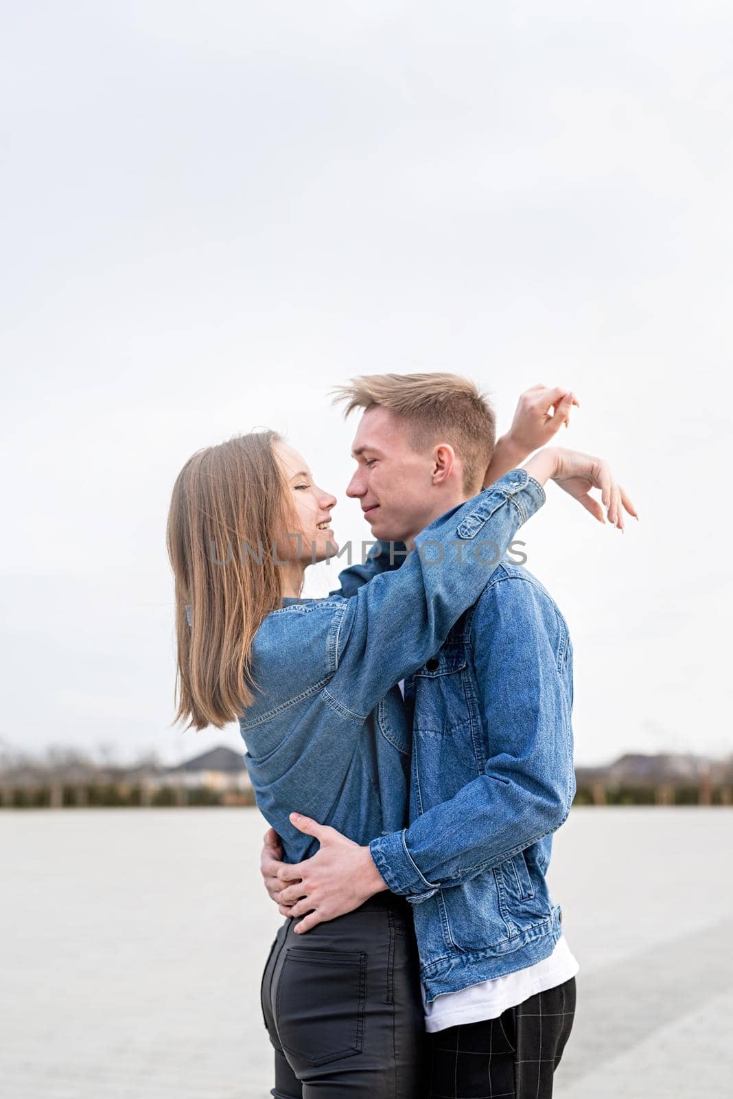 Happy young loving couple embracing each other outdoors in the park having fun