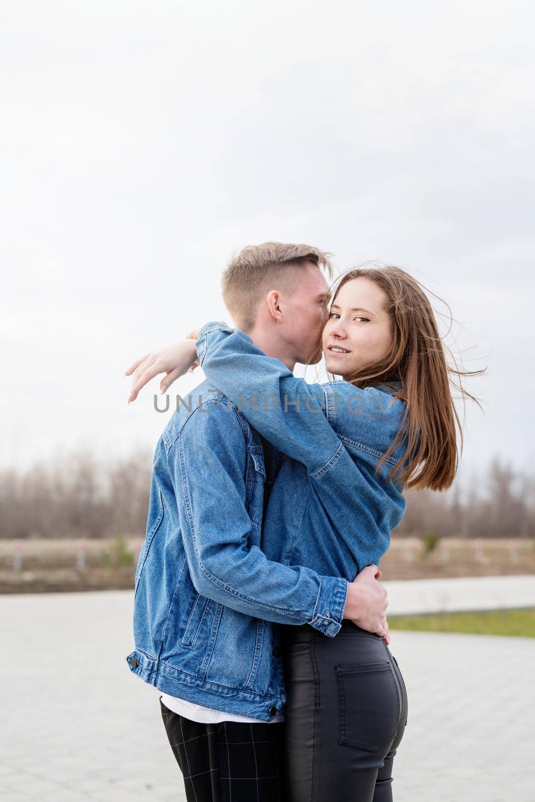 Young loving couple embracing each other outdoors in the park by Desperada