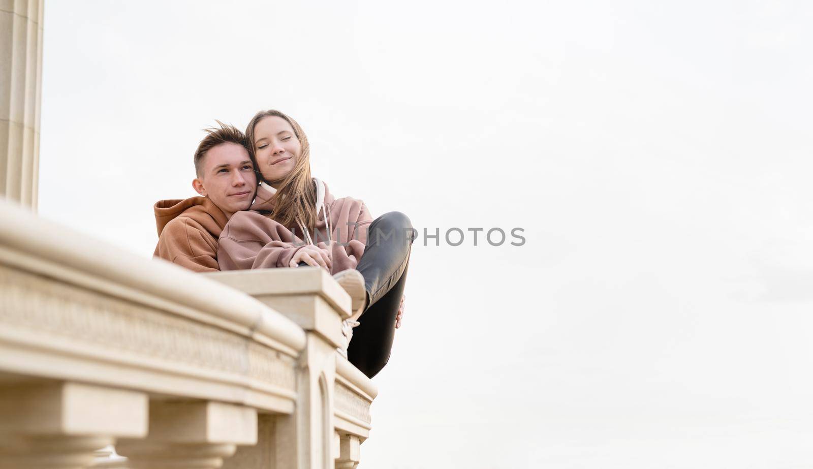 Happy young loving couple embracing each other outdoors in the park having fun