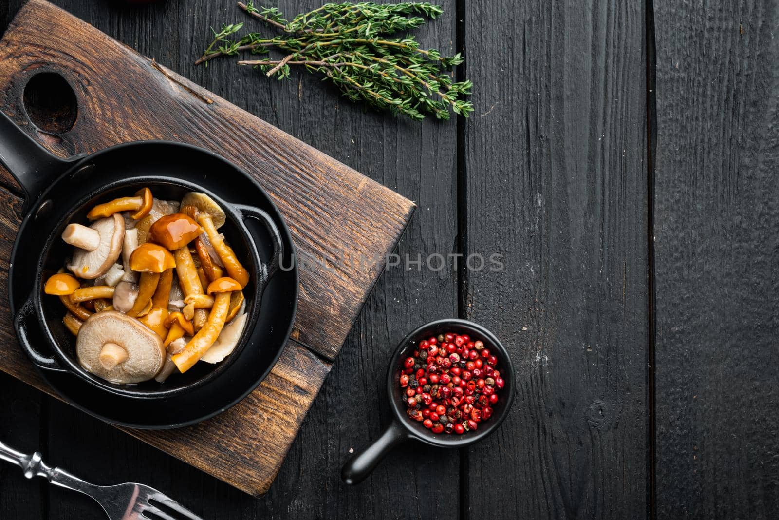 Pickled mushrooms set, on black wooden table background, top view flat lay , with space for text copyspace