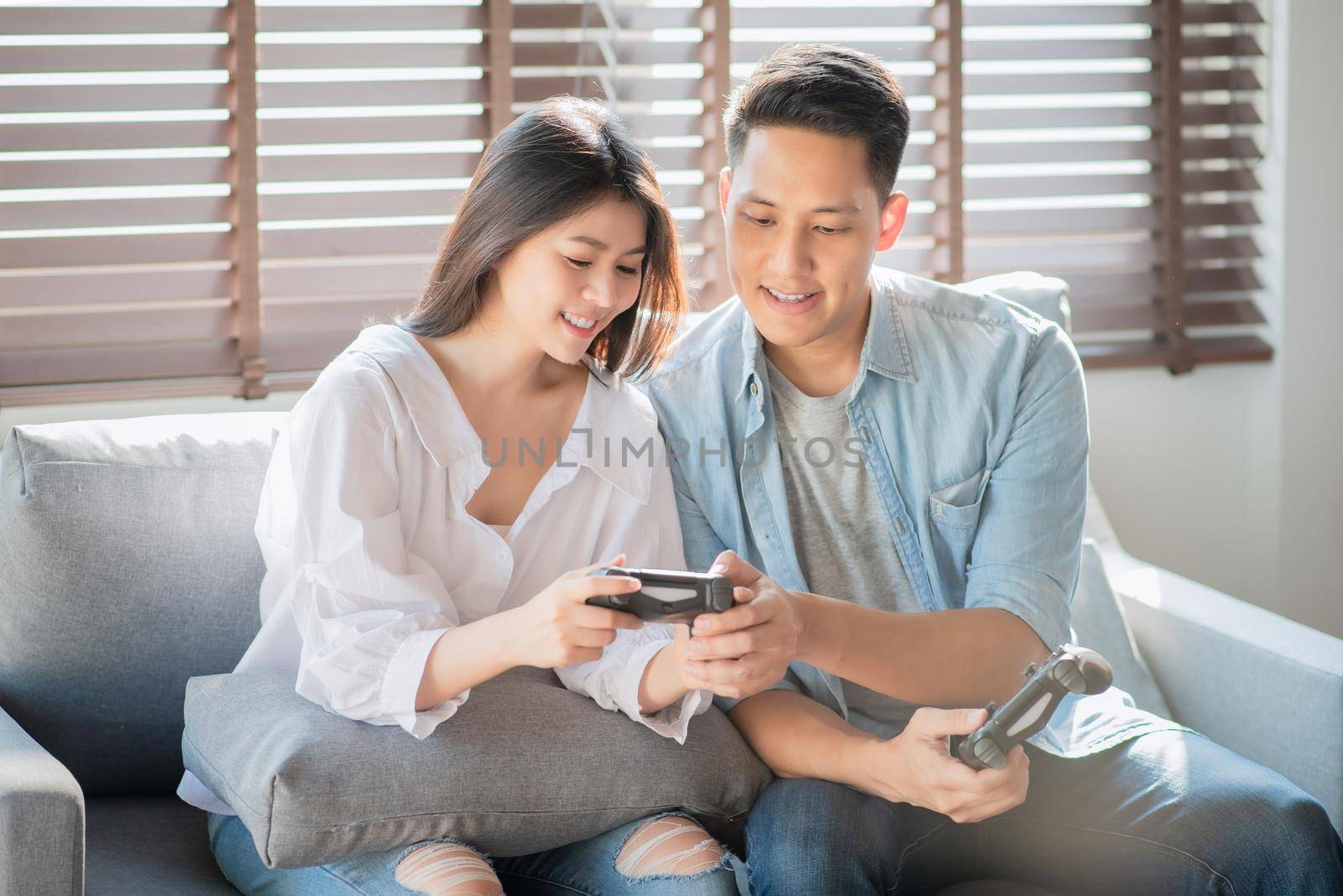 Asian couple lovers enjoy and play console game on vacation make more quality time of happiness together at home