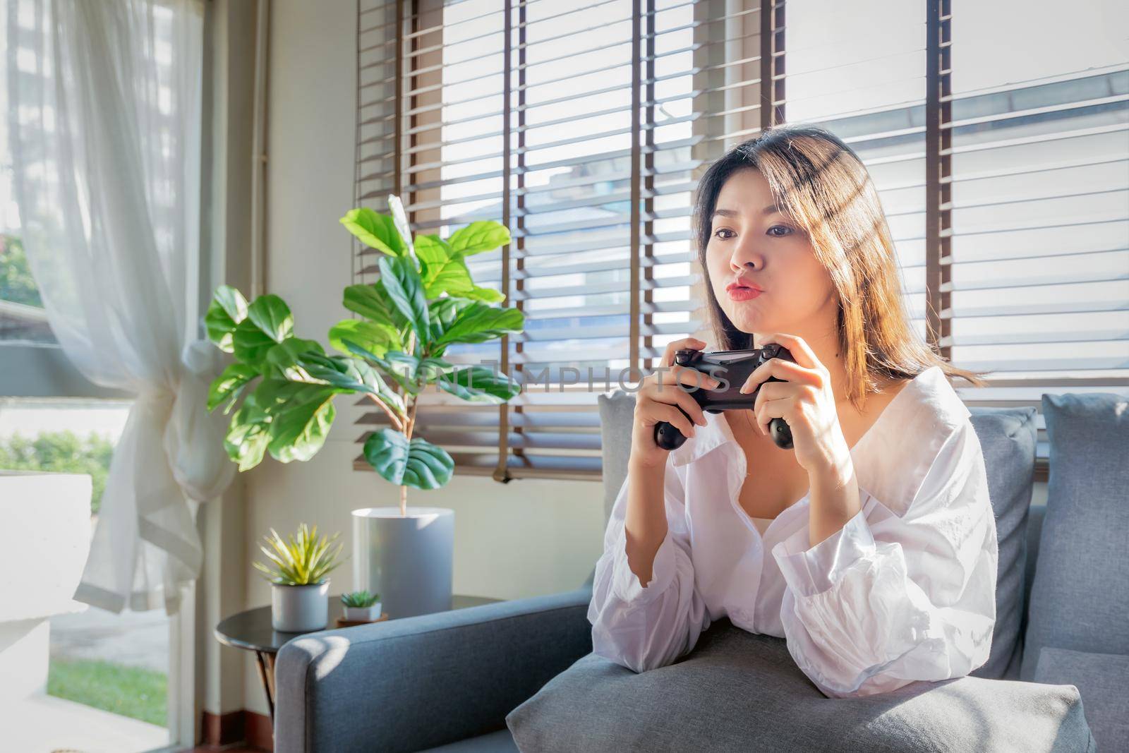 Asian women work from home by casting game streaming online via console game during corona virus or covid19 crisis follow the Social Distancing regulation.