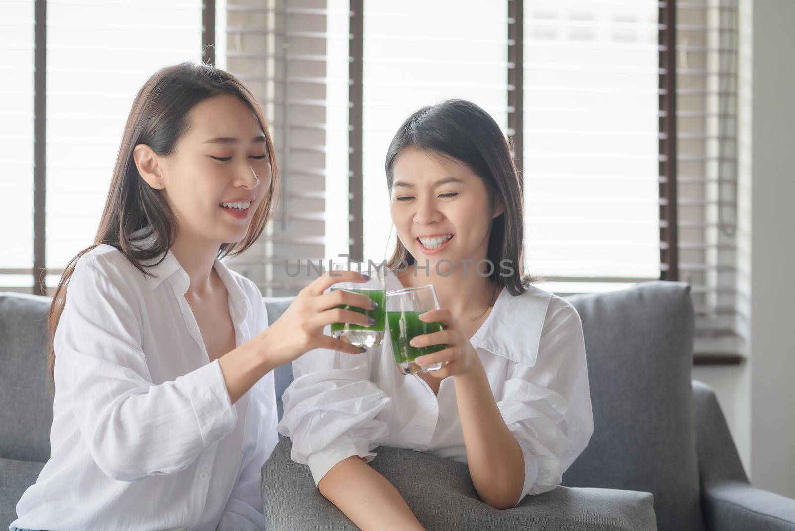Two beautiful woman enjoy drinking healthy drink during stay safe at home by Nuamfolio