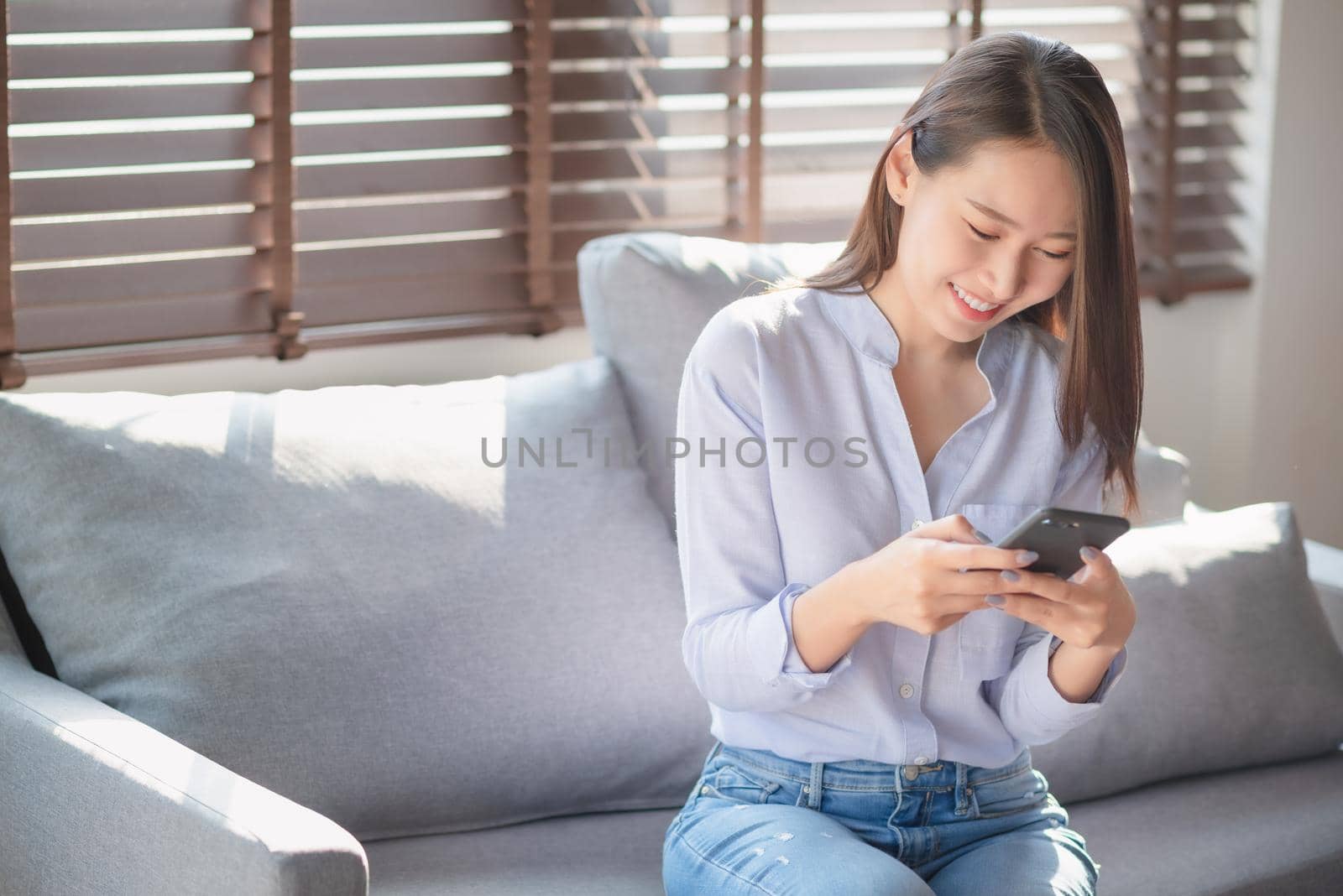 Beautiful woman using mobile phone and internet technology to use online chat with her friends during stay safe at home