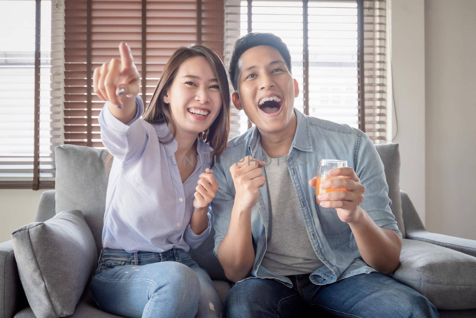 Asian couple lovers enjoy watching entertainment internet streaming via smart television for stay safe at home
