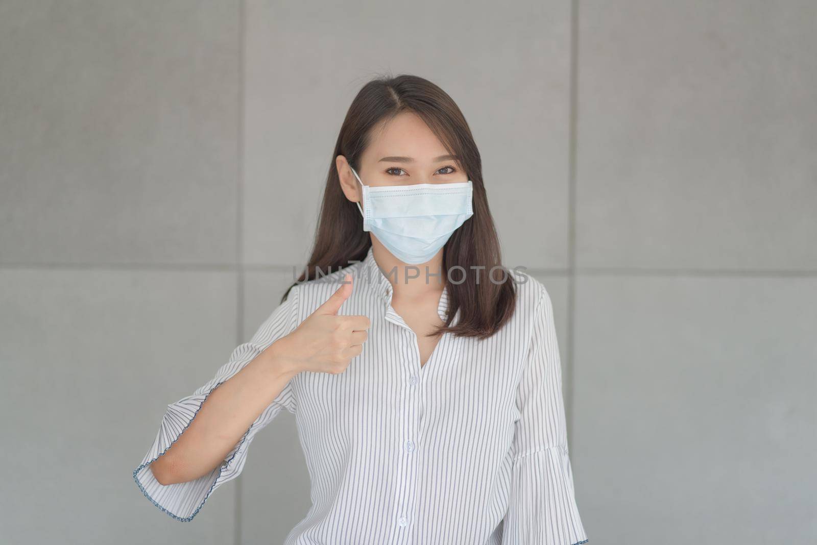 Business employee wearing mask during work in office to keep hygiene follow company policy by Nuamfolio
