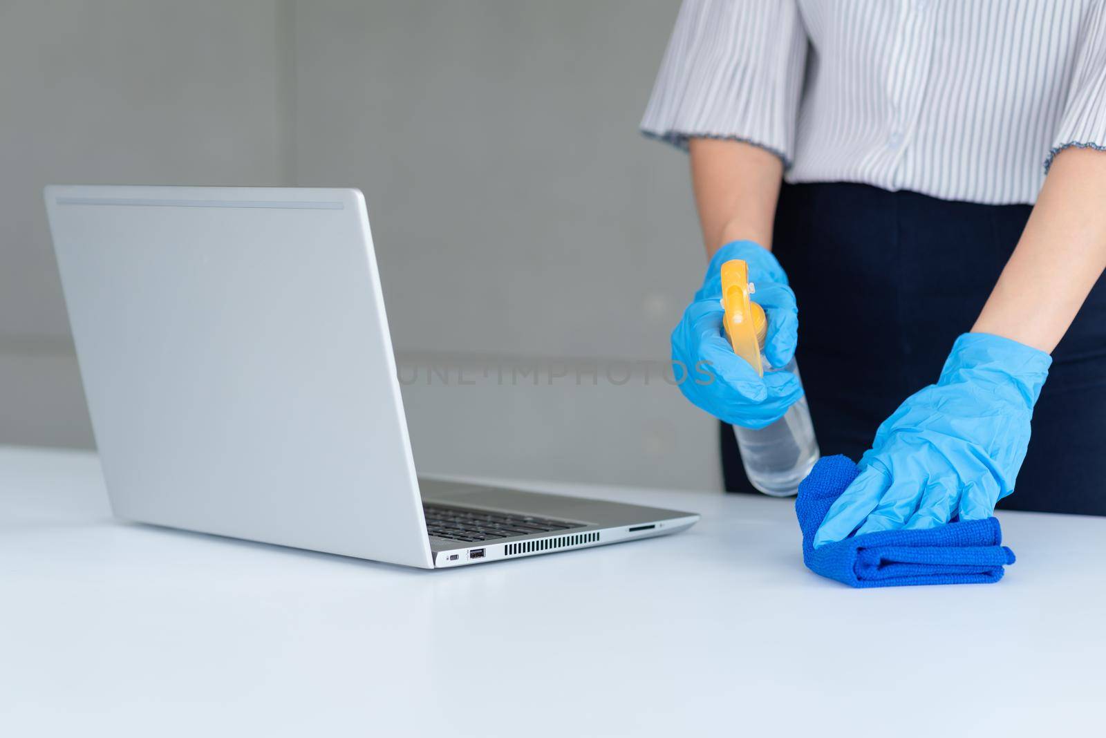 Business woman wearing mask and using personal sanitizer to cleaning her table in office to keep hygiene.Preventive during the period of epidemic from coronavirus or covid19.