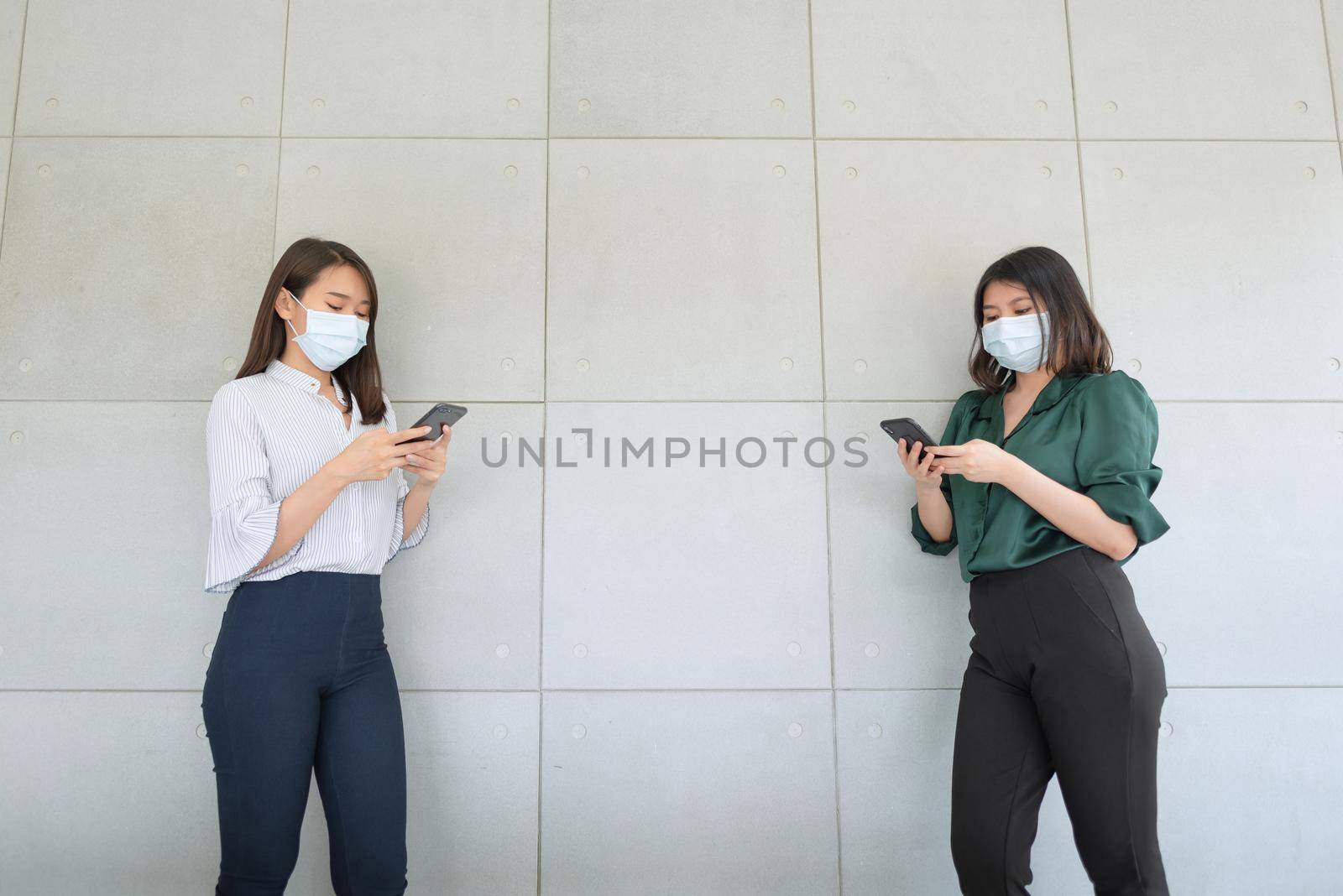 Business employees wearing mask during work in office to keep hygiene follow company policy. by Nuamfolio