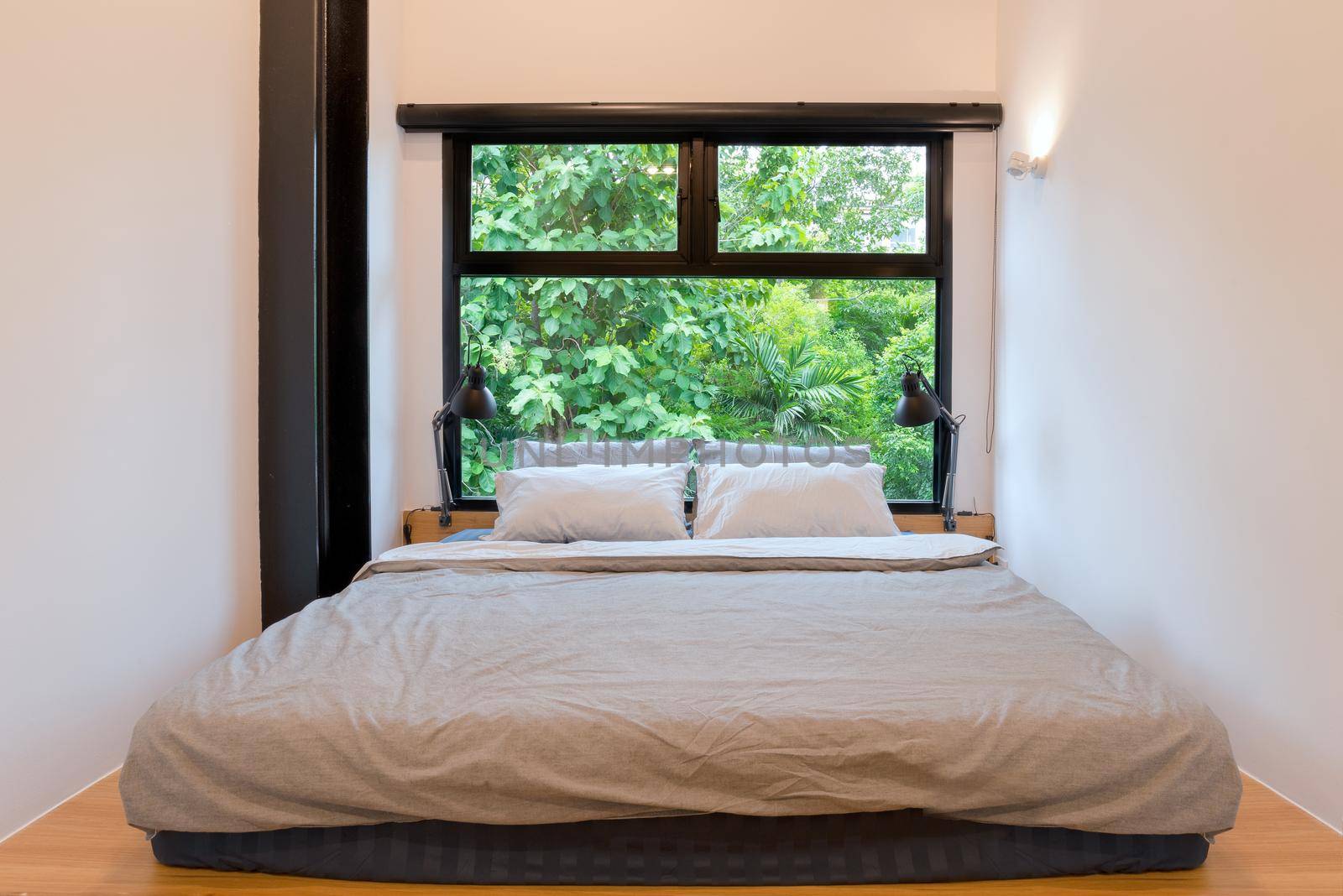 Bedroom with fresh nature green tree view through the window