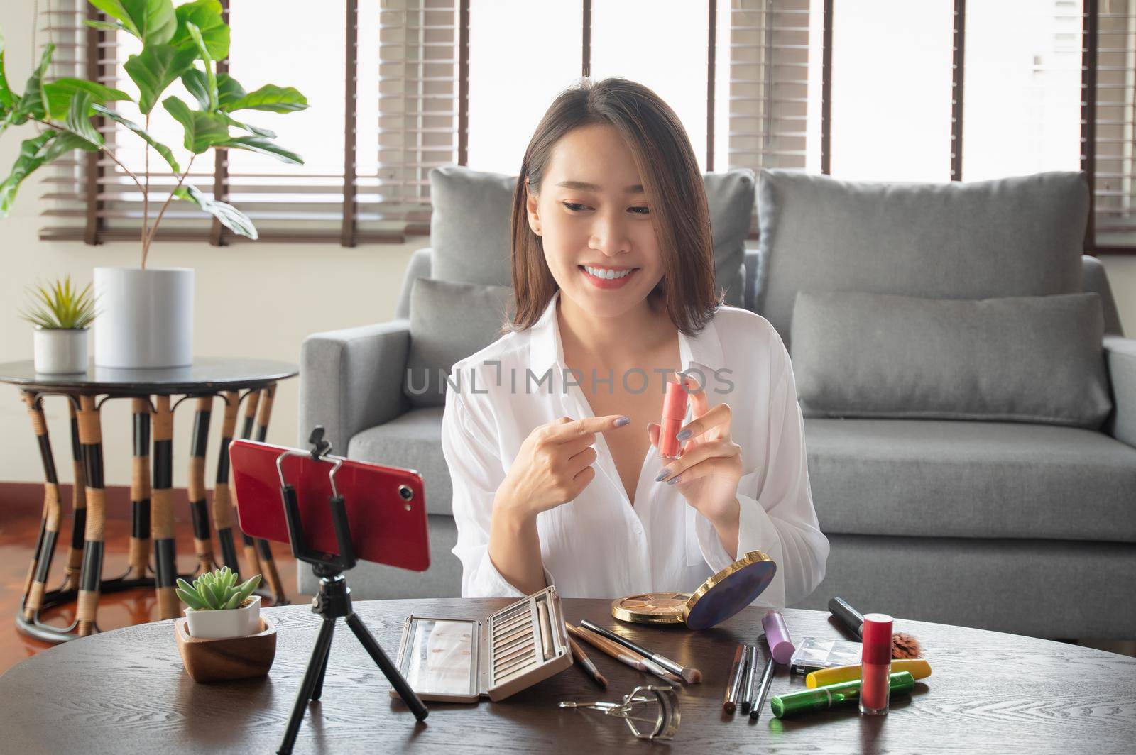 Female beauty influencer making a video tutorial for her beauty channel on cosmetics during stay safe at home