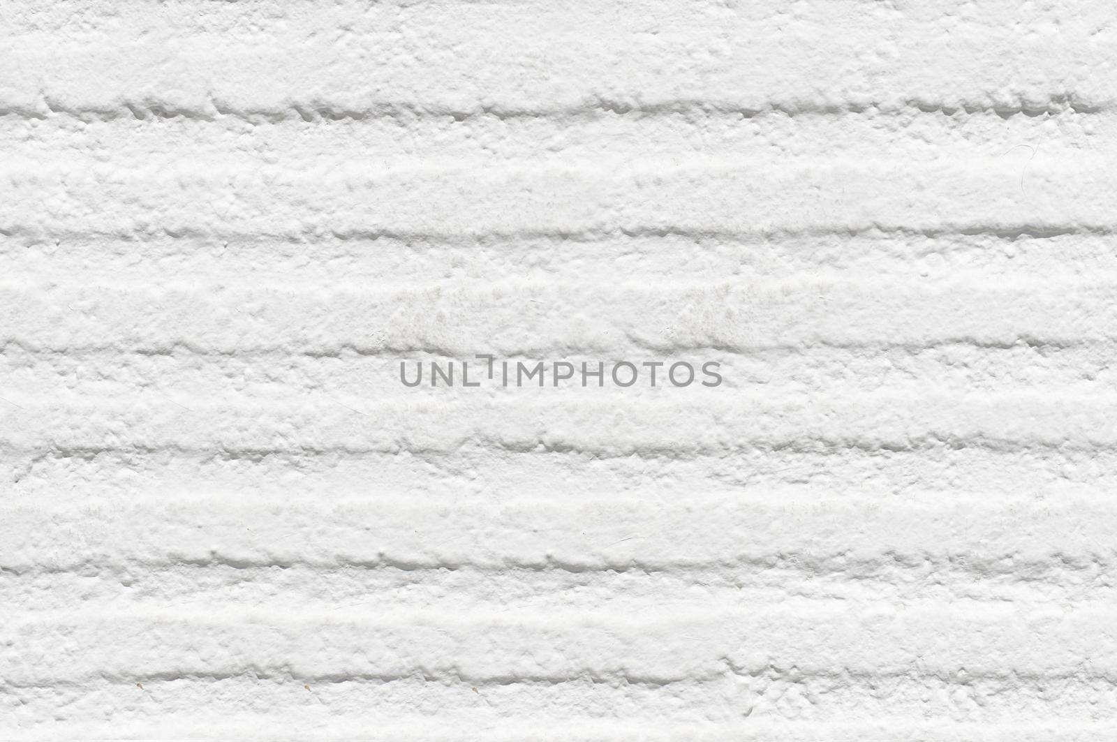 The wall is white with horizontal depressions and roughness on the surface.Texture or background