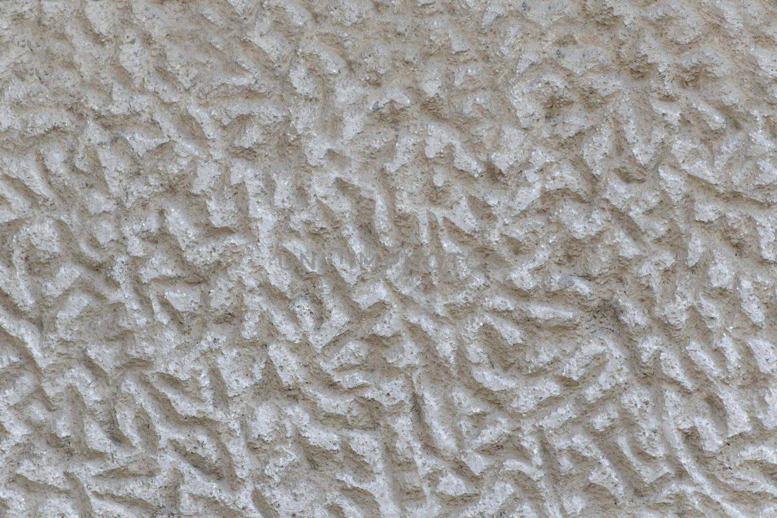 Close-up of a solid wall of rough gray cement with uneven depressions.Texture or background