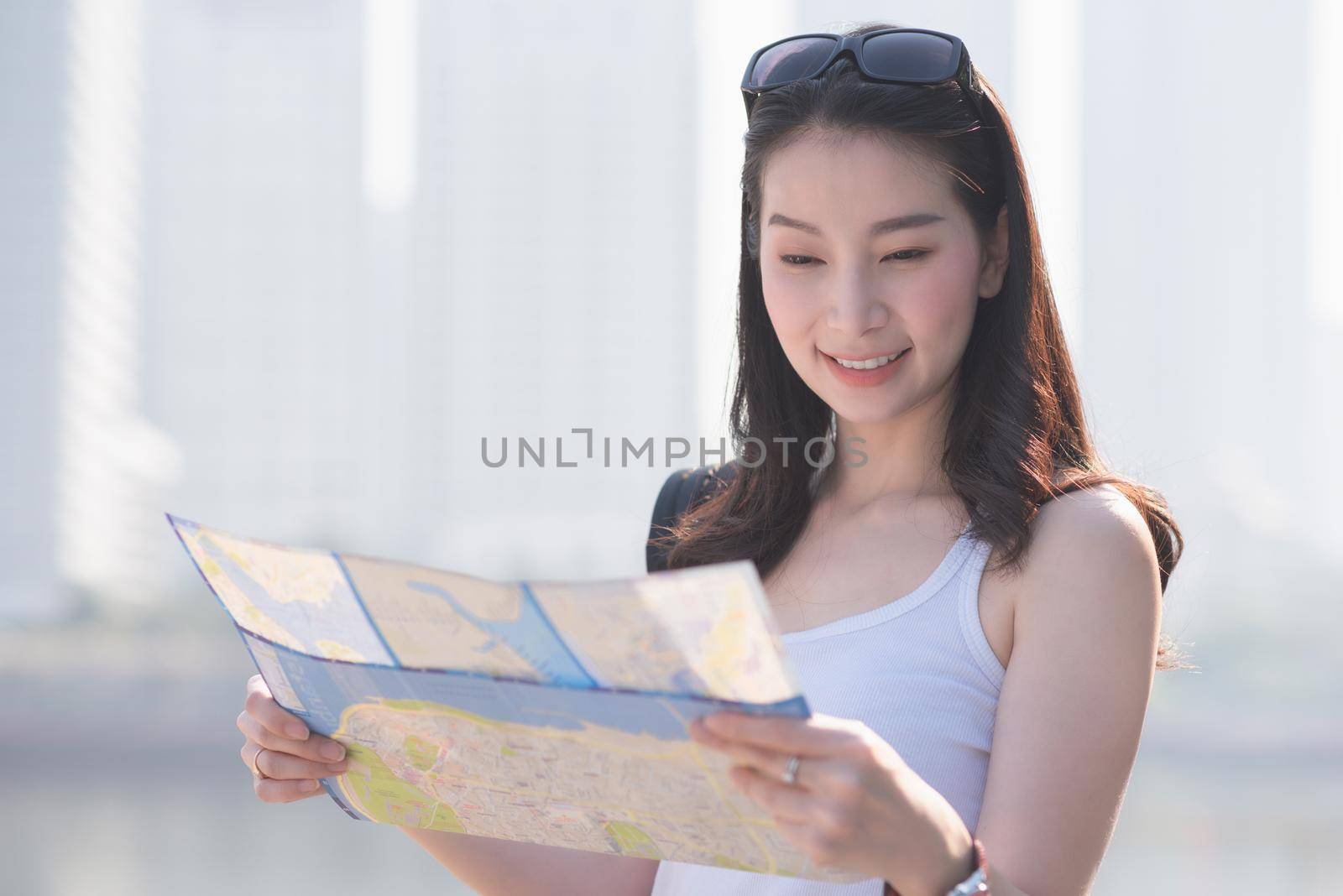 Beautiful asian solo tourist woman  looking at the map searching for tourists sightseeing spot. by Nuamfolio